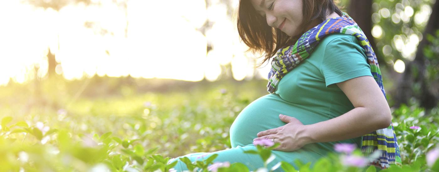 Pregnant Woman sitting in the woods
